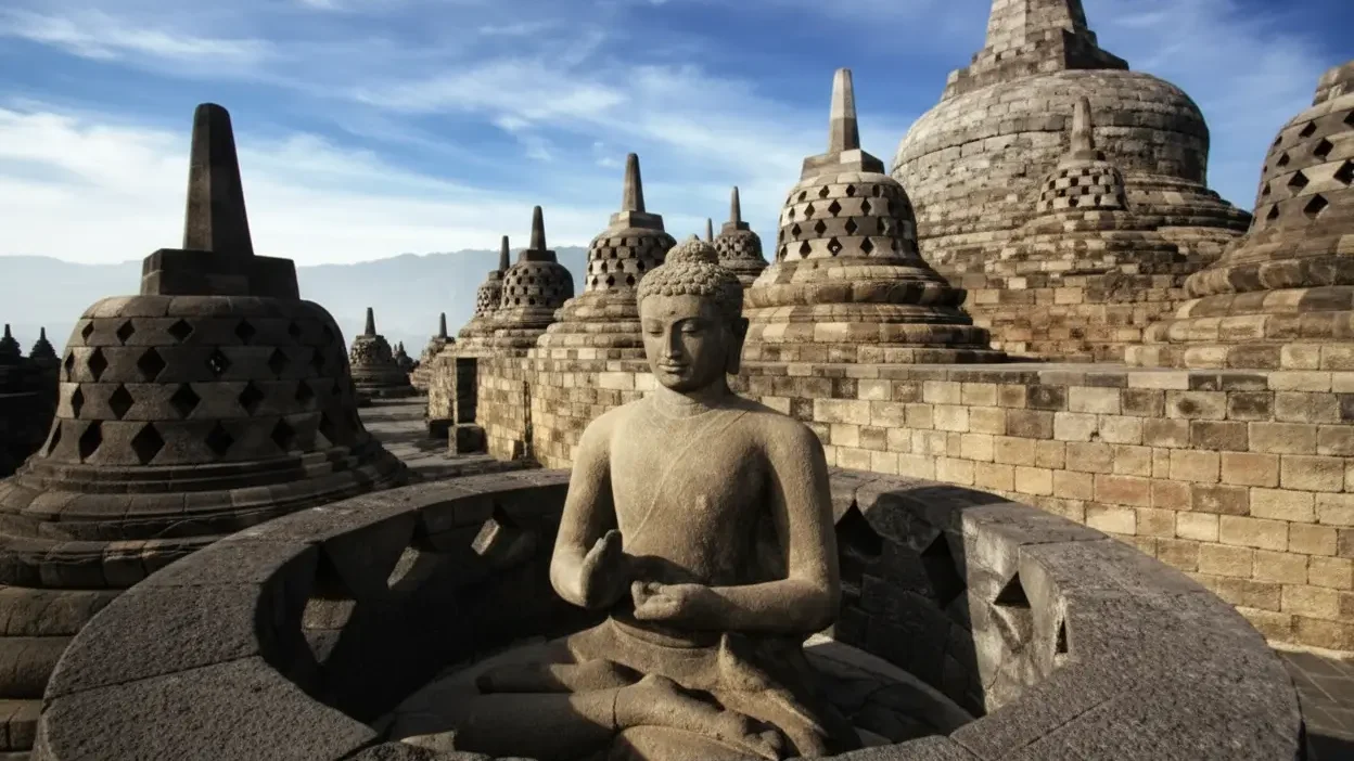 Buddha statue and stupas at Borobudur monastery, a spiritual home for monks in Indonesia.